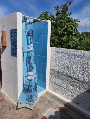 un muro di piastrelle blu con una tenda appesa sopra di Splendido villino con vista spettacolare a Ventotene