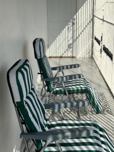 a row of green chairs sitting in a room at Thebreeze2022 in Kupuis