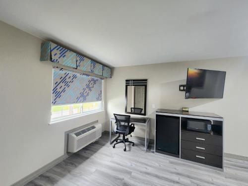 a room with a desk with a computer and a window at Days Inn by Wyndham Baytown TX in Baytown