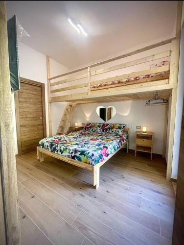 a bedroom with a bunk bed and a bed with a bedspread at Rosa Room in Castelnuovo Cilento
