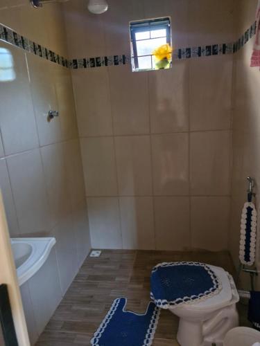 a bathroom with a toilet and a tub and a window at Mini casa interior Teixeira in Augusto de Lima