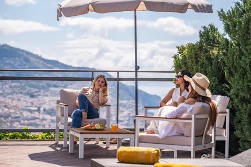 three women sitting in chairs on a patio with a view at Villa Beausoleil by Homie in Funchal