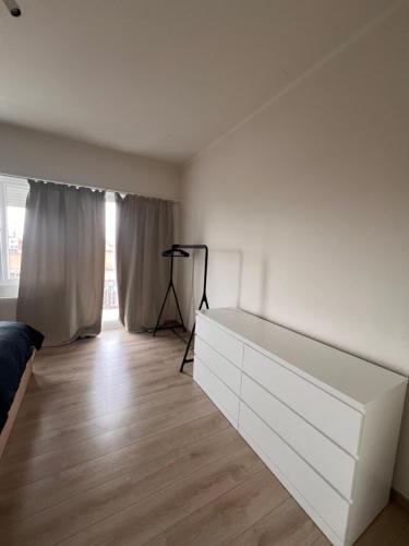 a white bedroom with a white dresser and a window at Cozy Feels, Central Vibes in Antwerp