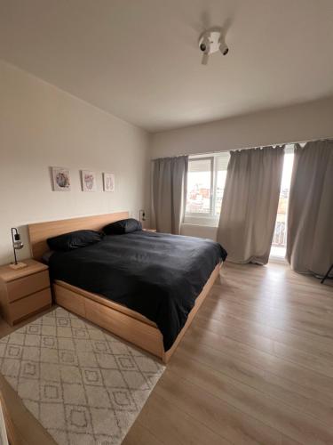 a bedroom with a bed and a large window at Cozy Feels, Central Vibes in Antwerp