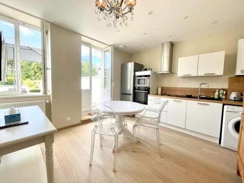 une cuisine avec une table et des chaises dans une pièce dans l'établissement Maison Cornat, Numéro 3, plein centre, à Valognes