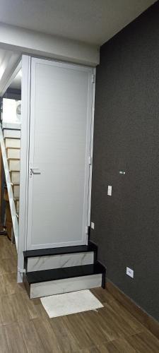 a large sliding door in a room with stairs at Aconchegante in Matinhos