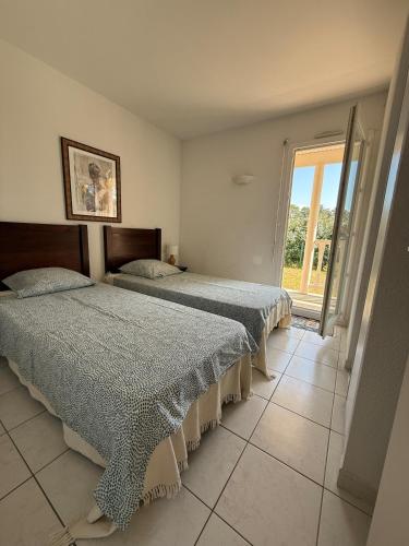 deux lits dans une chambre avec une fenêtre dans l'établissement Villa avec piscine 8p autour du golf, à Lacanau