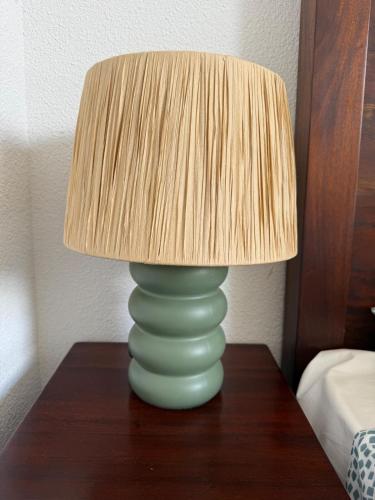 - une lampe verte sur une table en bois avec une lampe à l'ombre dans l'établissement Villa avec piscine 8p autour du golf, à Lacanau