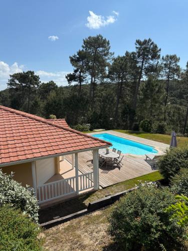 une maison avec une terrasse et une piscine dans l'établissement Villa avec piscine 8p autour du golf, à Lacanau