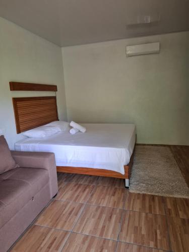 a small bedroom with a bed and a couch at Bungalow Batsù in Fortuna