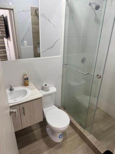a bathroom with a toilet and a glass shower at Casa de ensueño, con vista al Mar in Manta