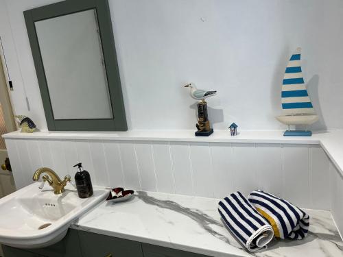 a white bathroom with a sink and a mirror at Charming Devon Cottage near Quay-Rain Shower, Restaurants & Free Parking in Kingsbridge