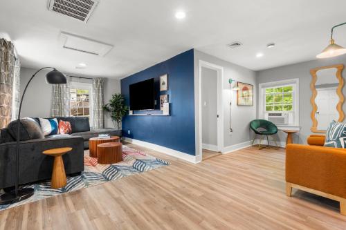 a living room with a black couch and a blue wall at Walk to Mohegan! Modern 3BR Home Getaway in Norwich
