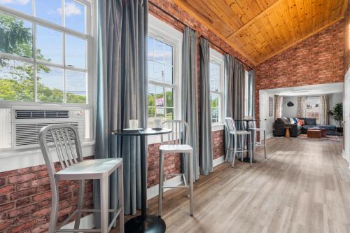 a room with windows and tables and chairs at Walk to Mohegan! Modern 3BR Home Getaway in Norwich