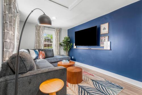 a living room with a gray couch and a blue wall at Walk to Mohegan! Modern 3BR Home Getaway in Norwich
