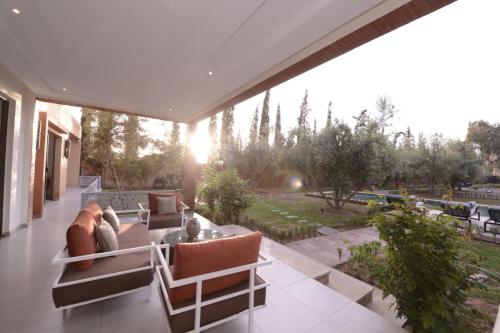 a living room with a couch and chairs on a patio at Villa Essalam Marrakech in Marrakech