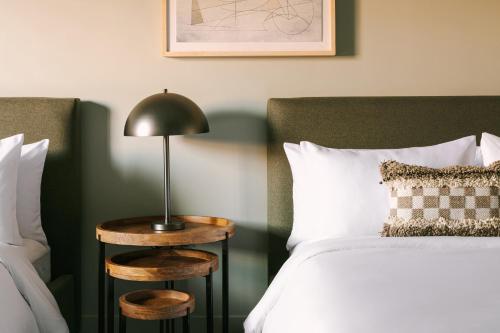 a bedroom with a bed and a lamp on a side table at Hotel Solarena in Newport Beach