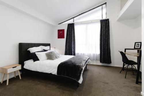a bedroom with a large bed and a window at Spacious 3BR Retreat on City Fringe w Free Parking in Wellington