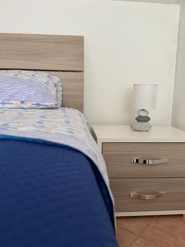 a bedroom with a bed and a nightstand with a lamp at CasaMì Experience Nuvola in Acquavella