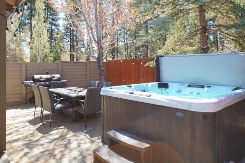 a hot tub on a patio with a table and chairs at The Bear Den - DREAM LOCATION WALKING DISTANCE TO LAKE AND VILLAGE! in Big Bear Lake
