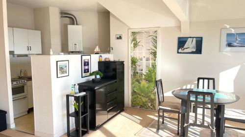 Il comprend une cuisine équipée d'une table, d'un réfrigérateur, d'une table et de chaises. dans l'établissement Plaisance, à Granville