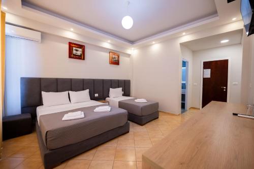 a bedroom with a bed and a couch and a table at Hotel Milo Ksamil in Ksamil