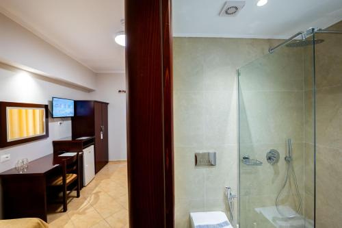 a bathroom with a shower and a table and a dining room at Hotel Milo Ksamil in Ksamil