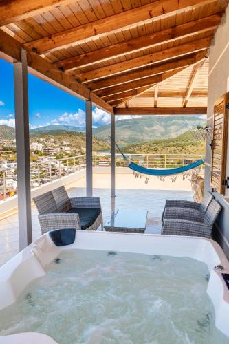 a hot tub on a patio with chairs and a hammock at Hotel Milo Ksamil in Ksamil