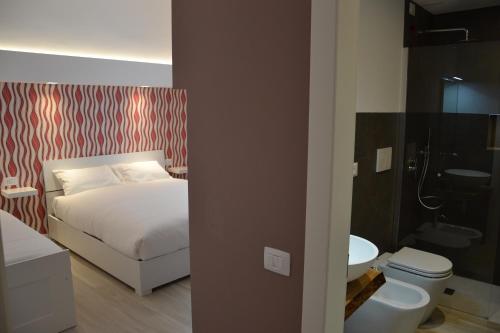 a bedroom with a bed and a bathroom with a toilet at In Centro Glam in Bergamo