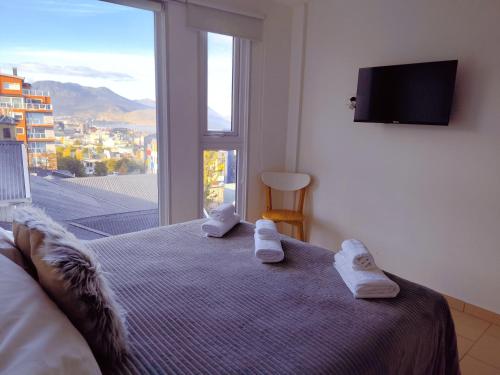 a bedroom with a bed with towels on it at Céntrico con vistas Ushuaiayvos in Ushuaia