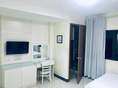 a bedroom with a desk with a television and a bed at Linh Anh Hotel in Hanoi