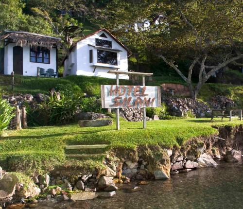 a sign in front of a house next to a river at Cuarto 2 in San Marcos La Laguna