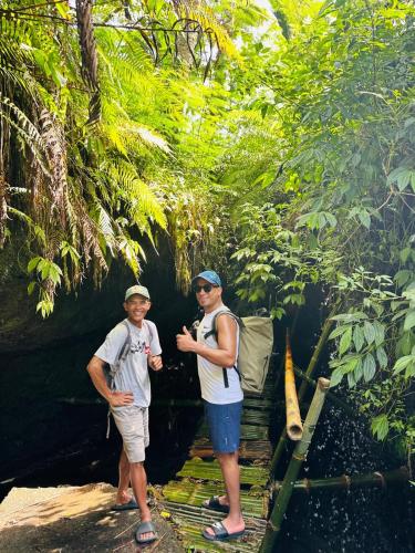two men standing in front of a dark cave at Rice Field inn - Lombok in Tetebatu