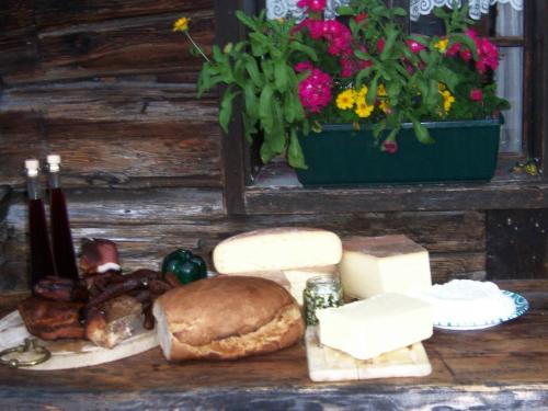 a table topped with cheese and a sandwich and other foods at Ferienhaus Schnitzhof in Abtenau
