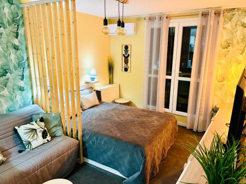 une chambre avec un lit et un canapé dans l'établissement Palm Leaf Studio Nice, à Nice