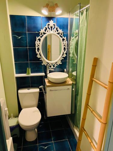 une salle de bain avec toilettes, lavabo et miroir dans l'établissement Palm Leaf Studio Nice, à Nice