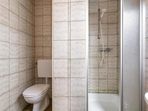a bathroom with a toilet and a glass shower stall at Schweizerhof Enzian in Huben