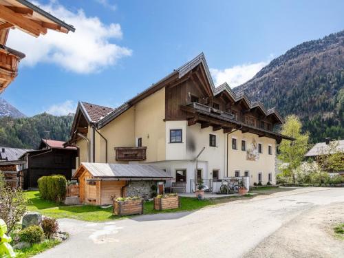 a large house with a mountain in the background at Schweizerhof Enzian in Huben