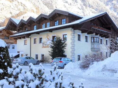 a large building with cars parked in front of it at Schweizerhof Enzian in Huben