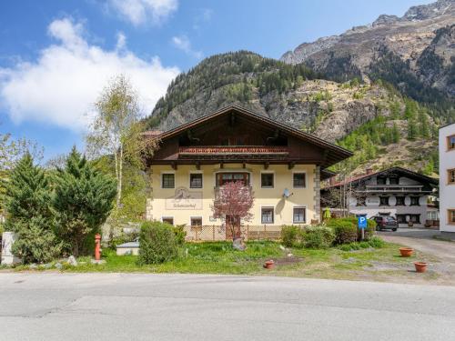 a building in front of a mountain at Schweizerhof Enzian in Huben