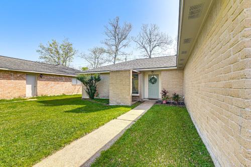 a house with a brick wall and a yard at 6 Mi to Clear Lake Family Home with Patio and Yard in Webster