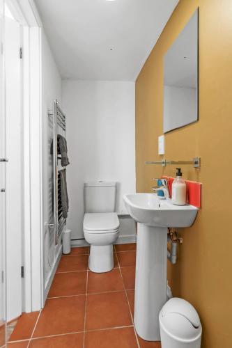 a bathroom with a toilet and a sink at The Wave - 3 bed beach front home in Sheringham in Sheringham