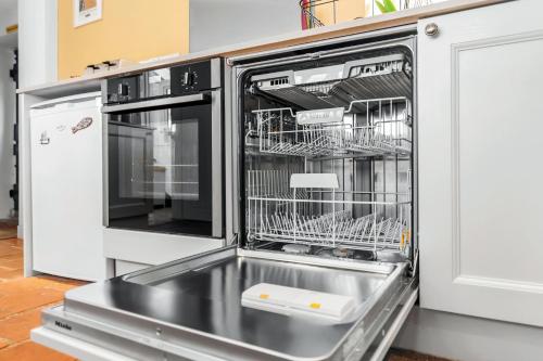 a dishwasher with dishes inside of it in a kitchen at The Wave - 3 bed beach front home in Sheringham in Sheringham