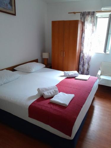a bedroom with a large bed with a red blanket at Apartments by the sea Prozurska Luka, Mljet - 4939 in Maranovići