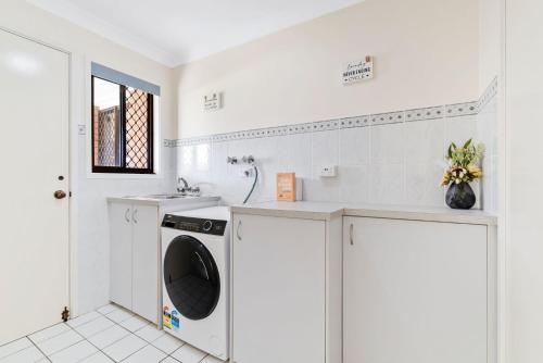 a white laundry room with a washing machine and a sink at Tweed Escape in Tweed Heads