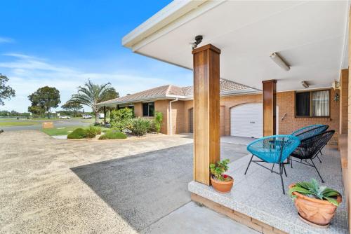 a porch with a blue chair and a house at Tweed Escape in Tweed Heads