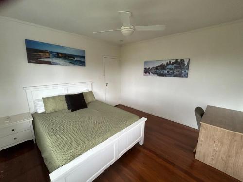 a bedroom with a white bed and a ceiling at Hill top 2-bedroom home with charming view in Brisbane