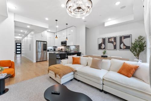 a living room with a white couch and a kitchen at Luxury 3BR Backyard Oasis Close to NYC FirePit in Jersey City