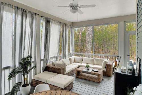 un soggiorno con divano e sedie su un portico di L'Hibou - 18 Farm View a Cherry Valley