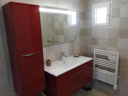 bagno con mobile rosso e lavandino di Gîte au bord du lac avec terrasse, idéal pour la famille - FR-1-611A-17 a Villegusien Le Lac